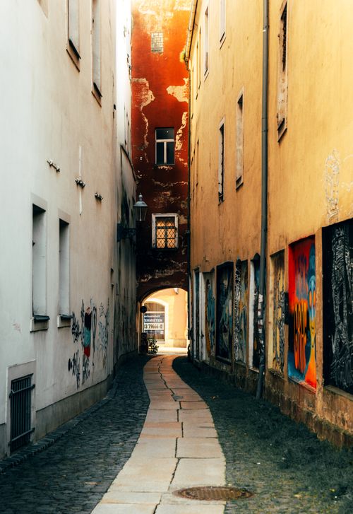 Free A narrow cobblestone alley with vibrant walls in Zittau, Germany. Stock Photo