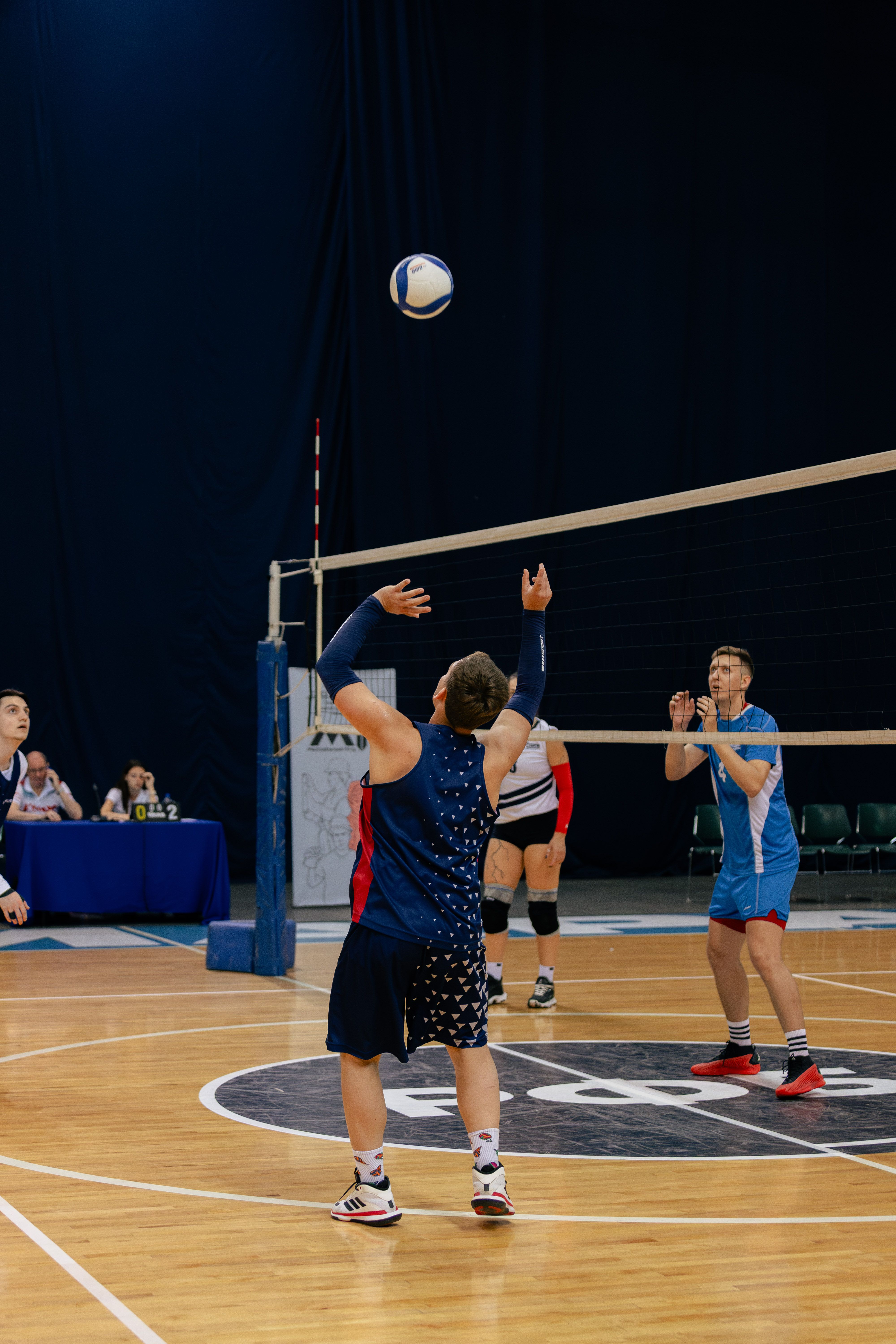 Dynamic action scene from an indoor volleyball match with players in motion.