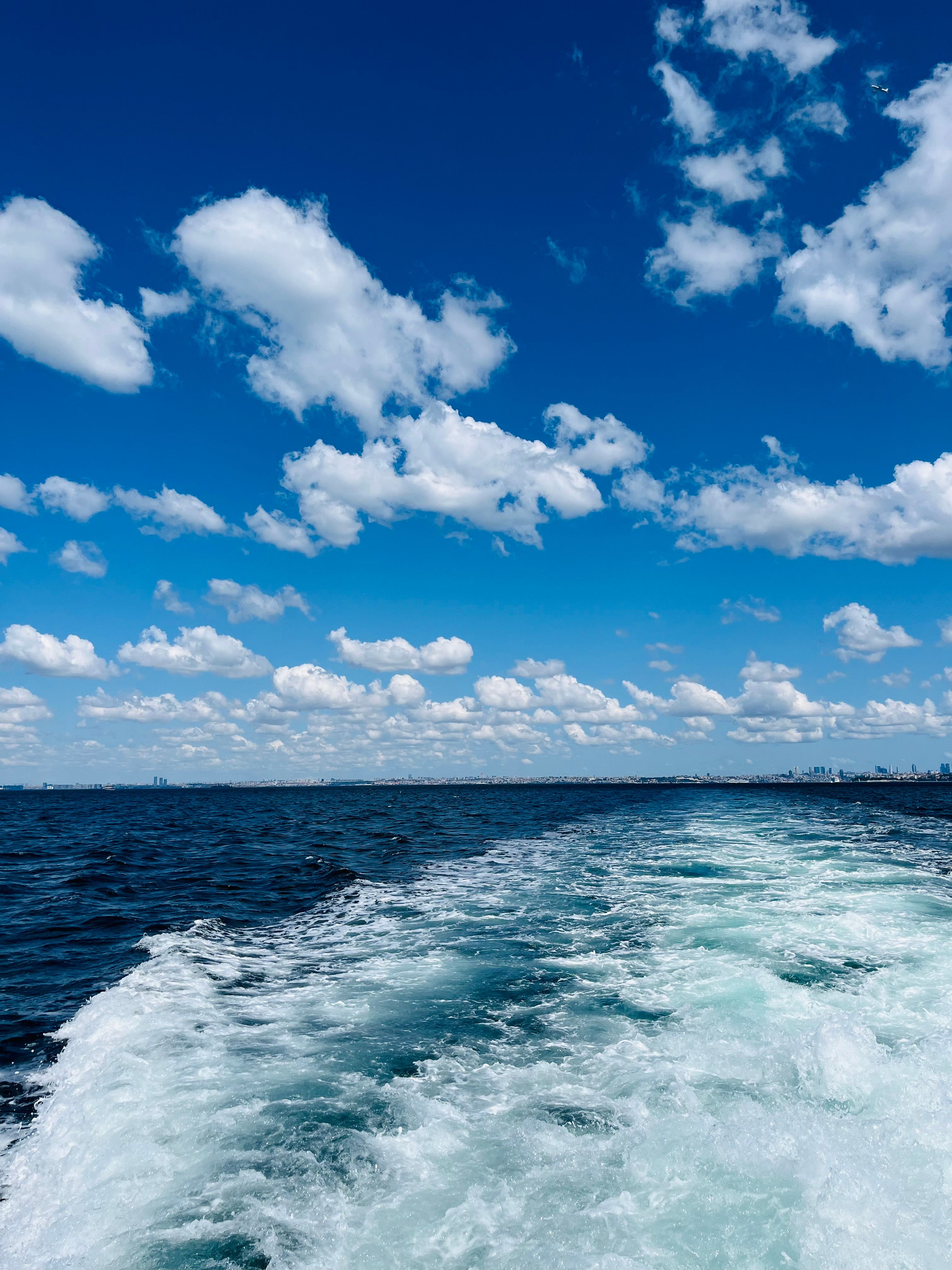 Ocean View with White Clouds Under Blue Sky · Free Stock Photo