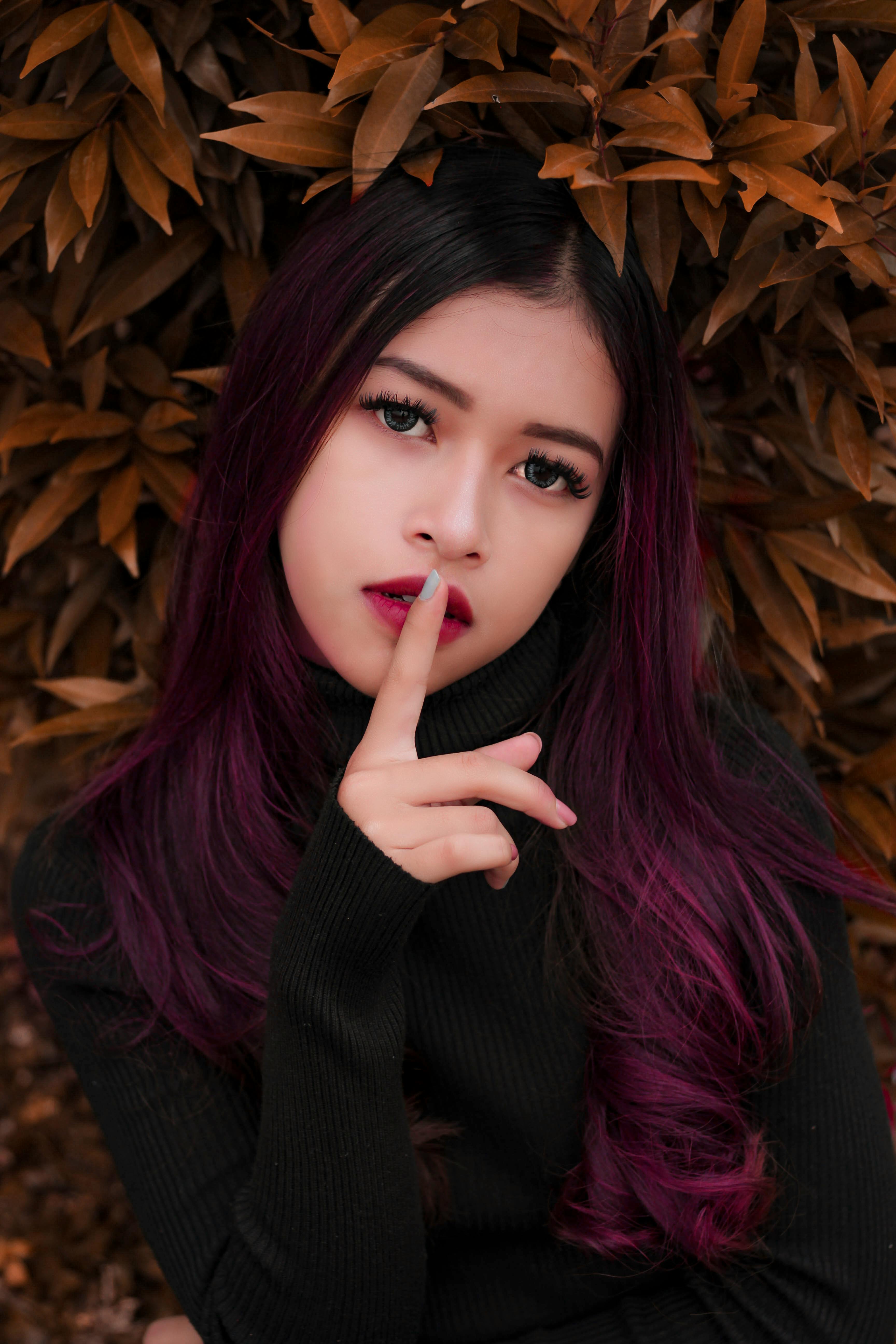 A woman with her finger on her lips · Free Stock Photo