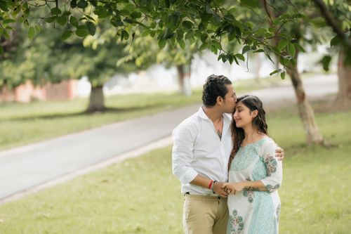 Free A couple shares a tender moment under a tree in a serene park, embodying love and togetherness. Stock Photo