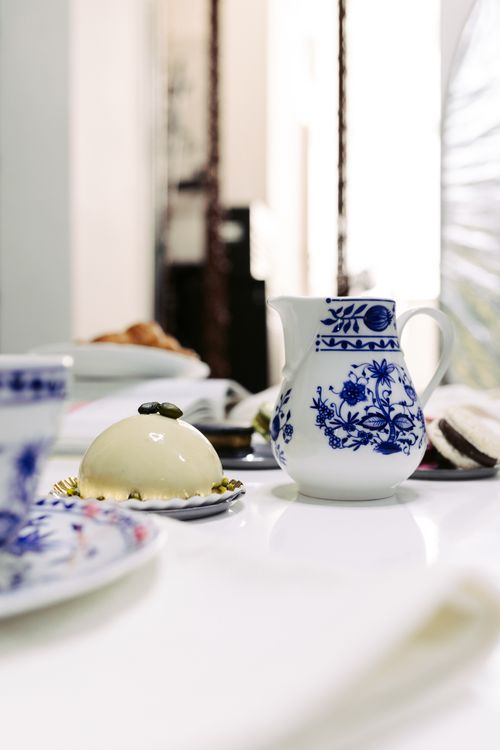 Free An elegant tea setting featuring blue floral china and a dessert on a white table. Stock Photo