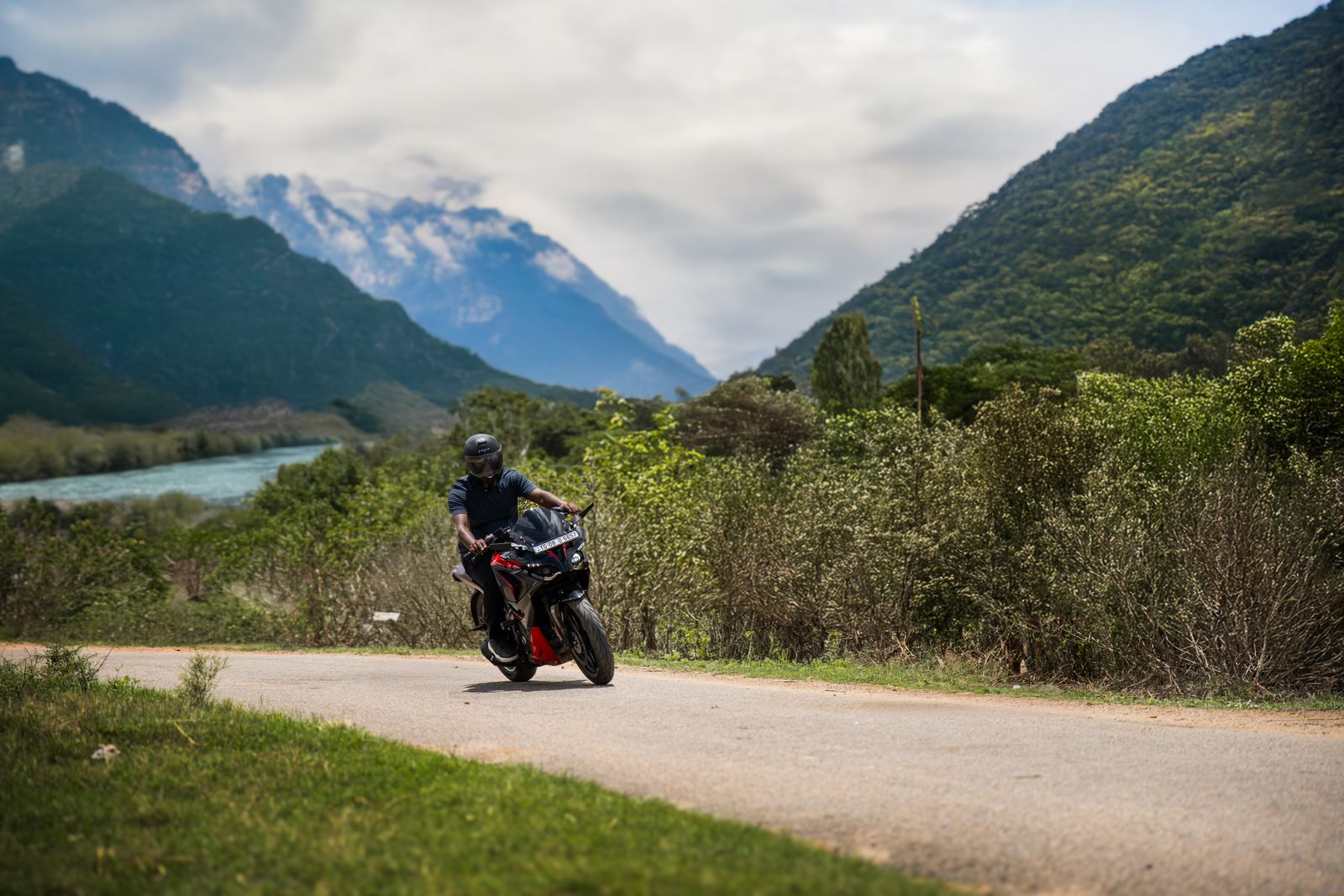 Motorcyclist riding on a scenic mountain road showing the journey guided by a skilled Easy Rider