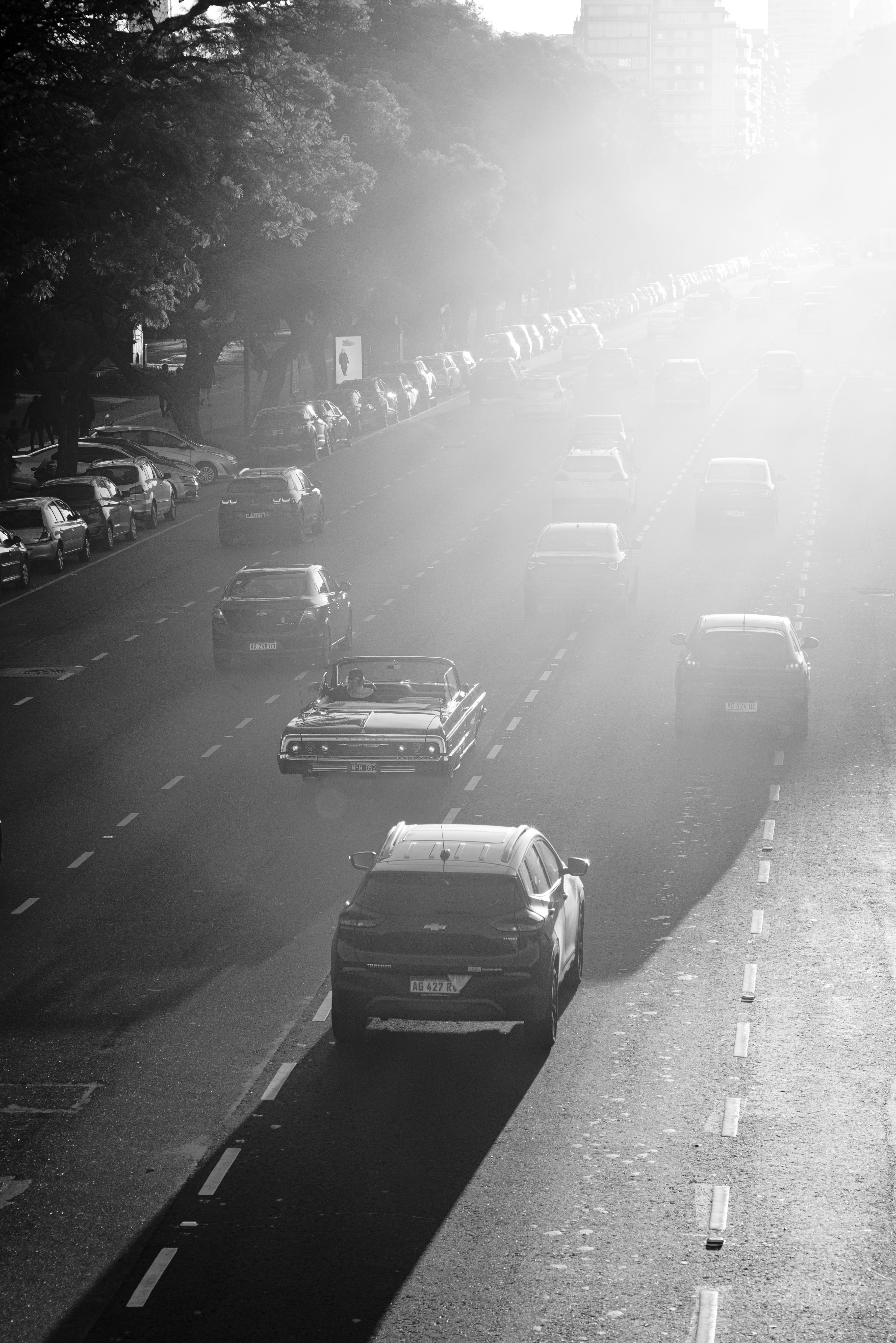 Black and white photo of cars on a sunlit street in Buenos Aires, Argentina.