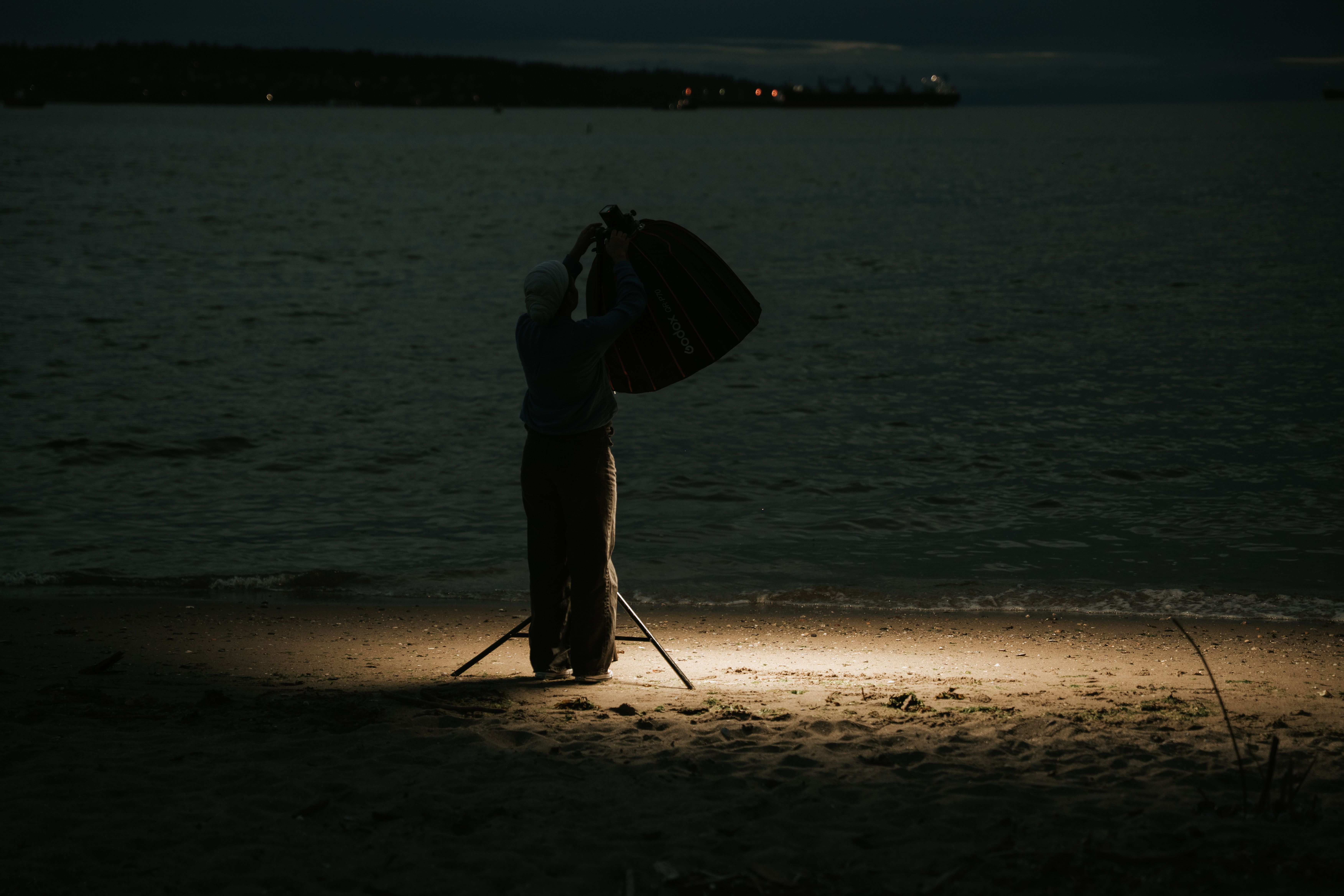 A photographer setting up a Sony camera on a tripod under a starry sky - how to composite night sky photos