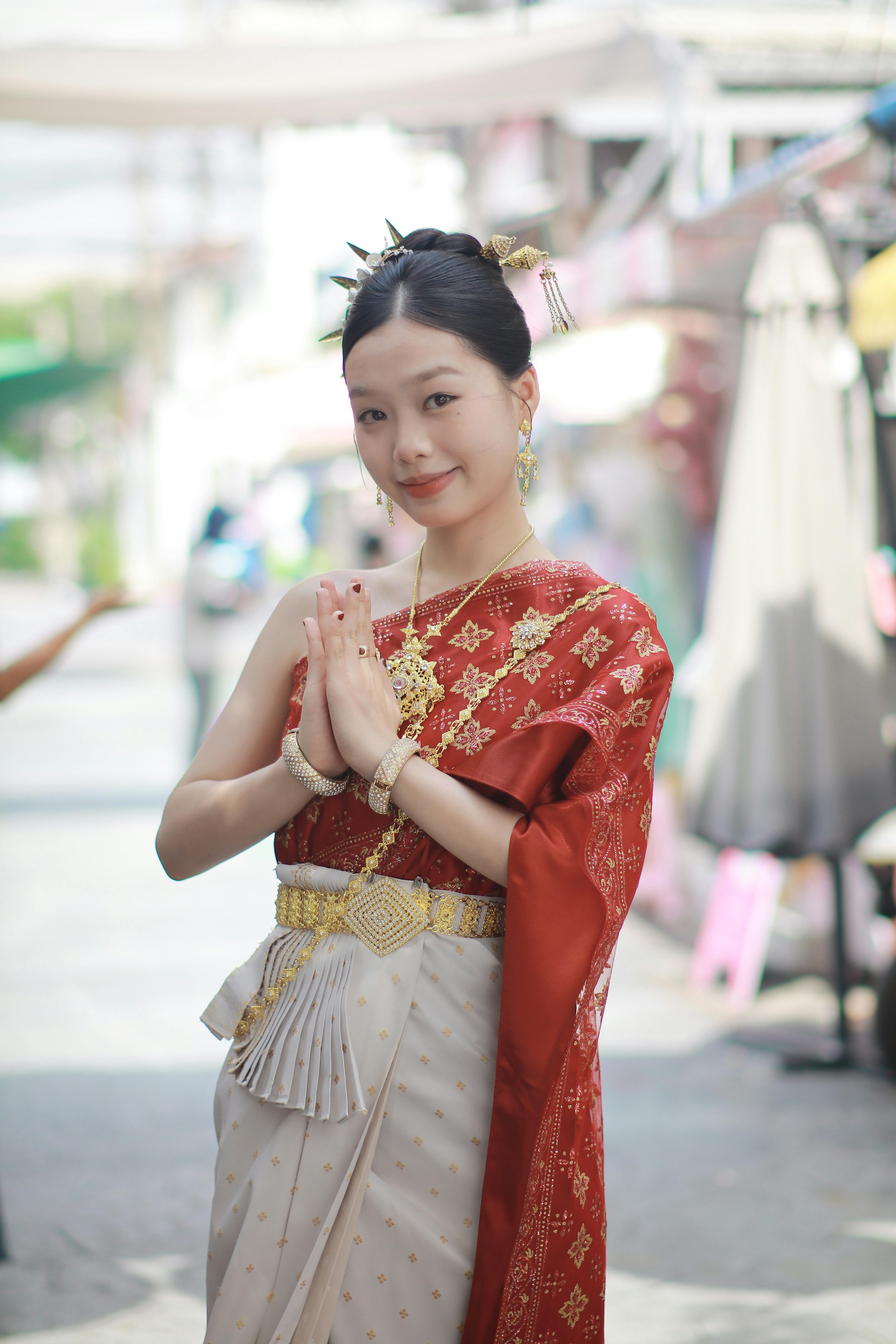 Elegant woman in traditional Thai attire posing outdoors in Bangkok.