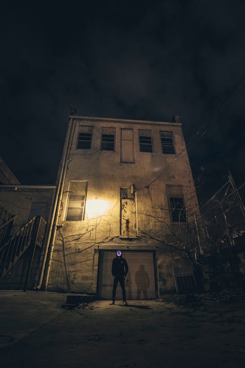 Man Standing in Front of Building during Nighttime