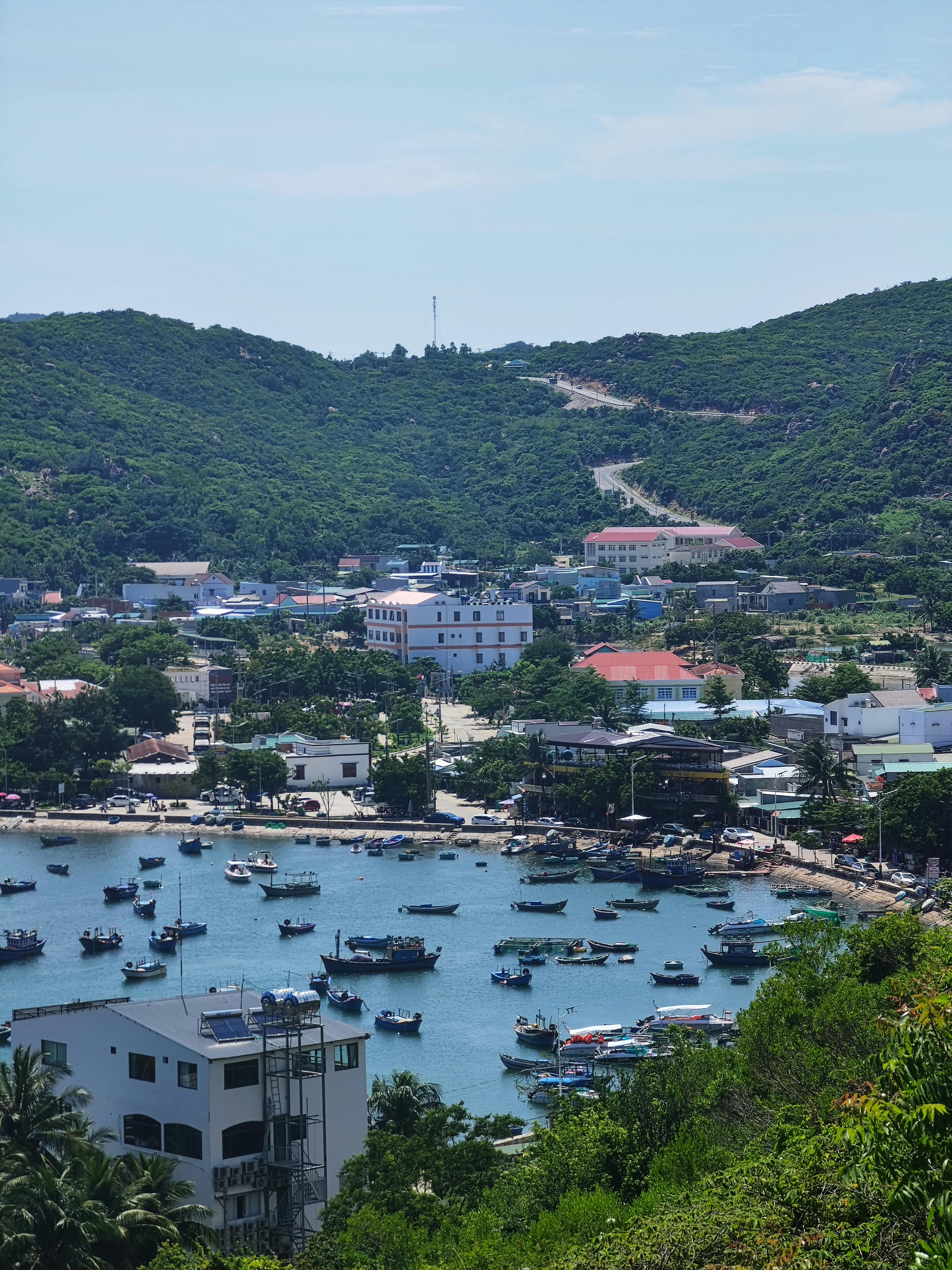 Picturesque harbor in Ninh Thuận, Vietnam, showcasing boats and lush hills.