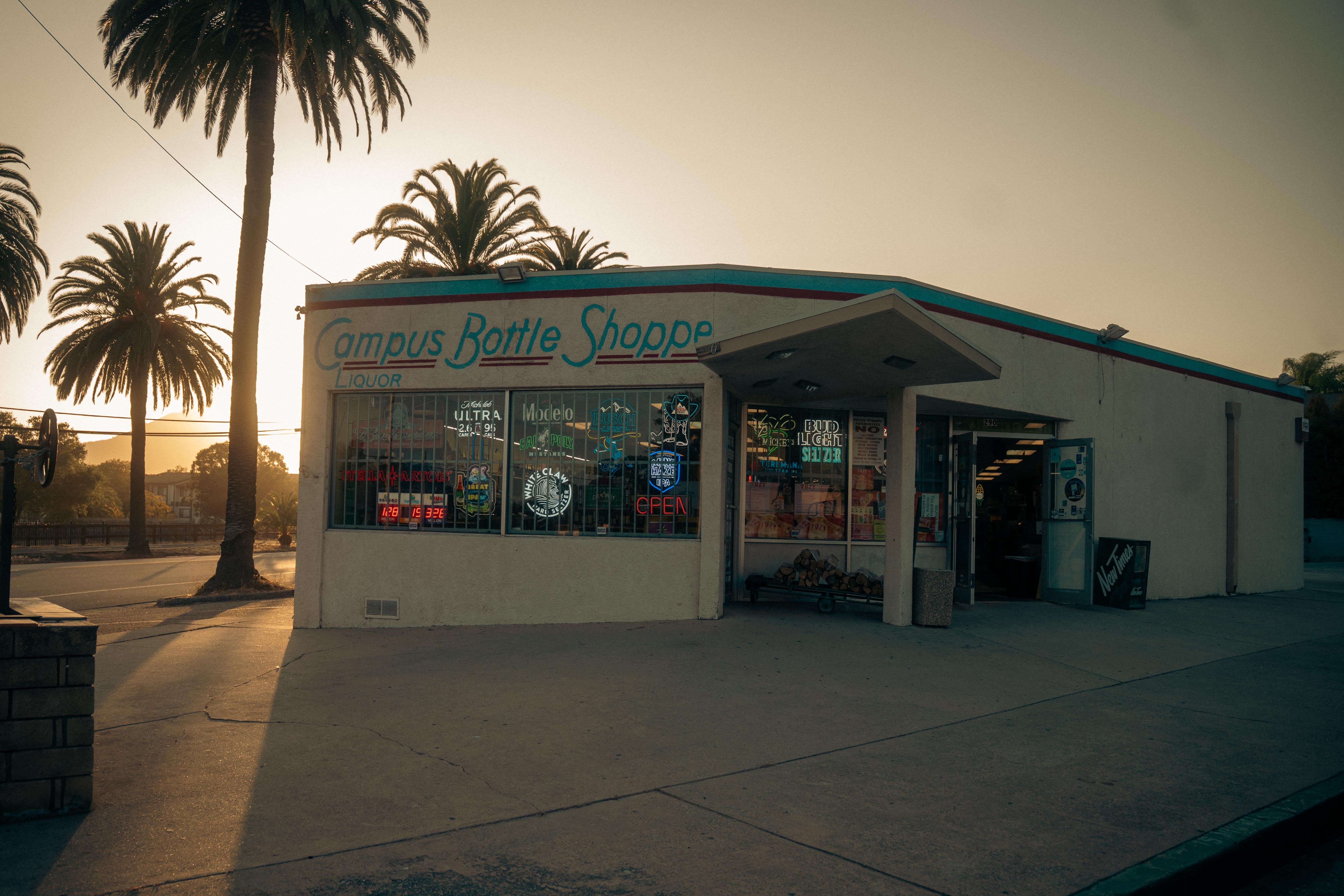 Photograph of Campus Bottle Shoppe at sunset with palm trees and vintage signage.