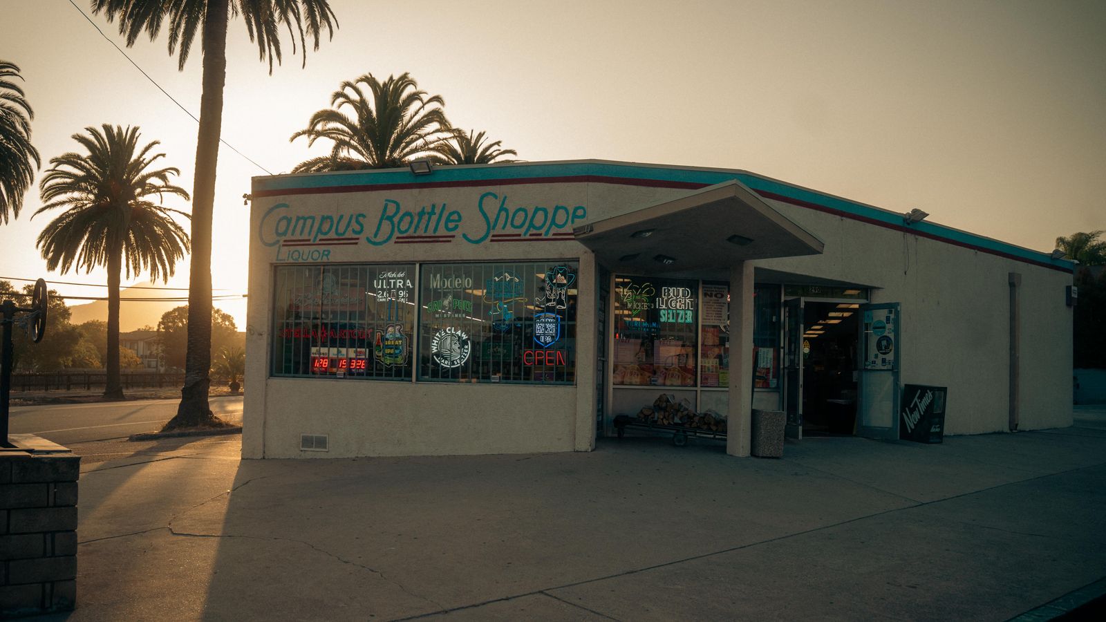 Photograph of Campus Bottle Shoppe at sunset with palm trees and vintage signage.