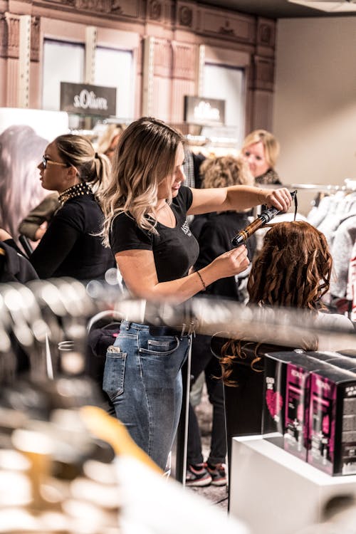 Free Woman Curling Another Woman's Hair Stock Photo