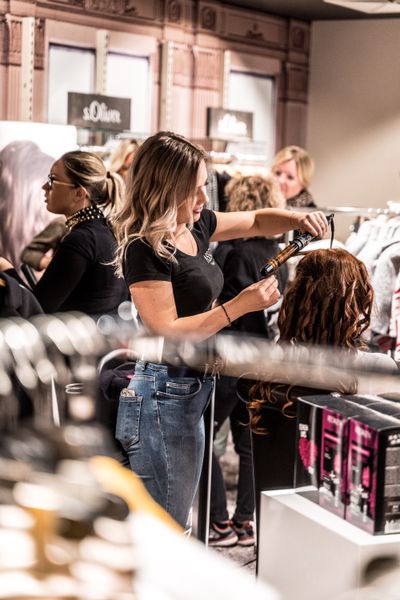 Stylist curling woman's hair
