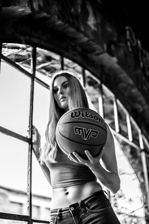 Grayscale Photography of Woman Holding Wilson Basketball