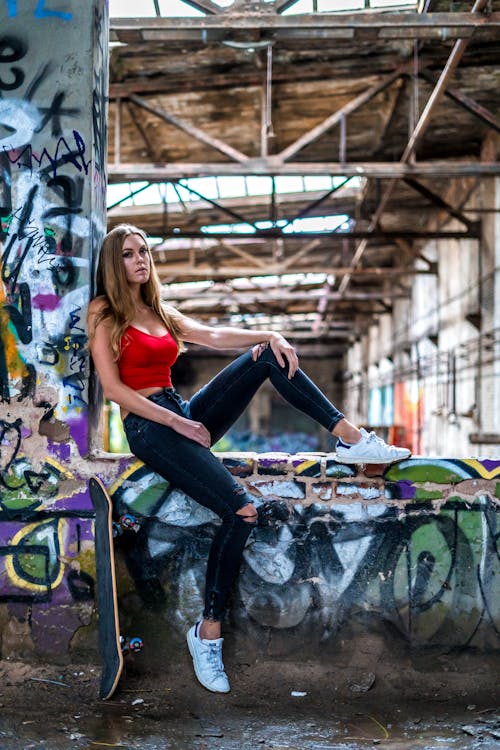 Woman in Red Crop-Top Sitting on Wall
