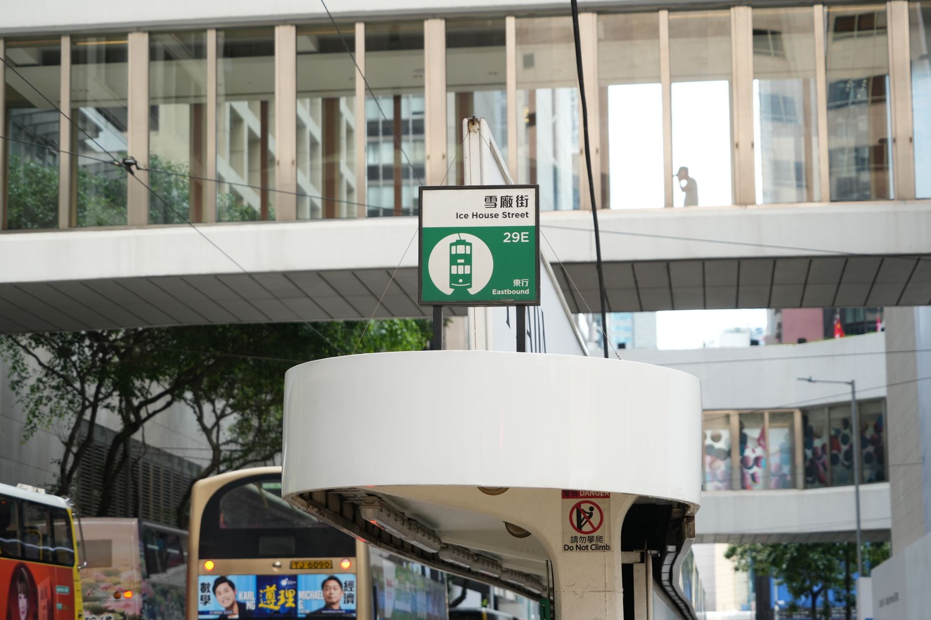 Tram stop signage at Ice House Street with modern architecture backdrop in Hong Kong.