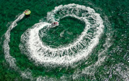 Free A thrilling aerial image of a jet ski towing a tube on emerald waters in Bodrum, Türkiye. Stock Photo