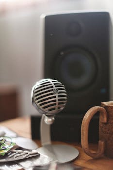 Retro-style microphone and speaker setup on a wooden table, capturing a cozy, vintage vibe.