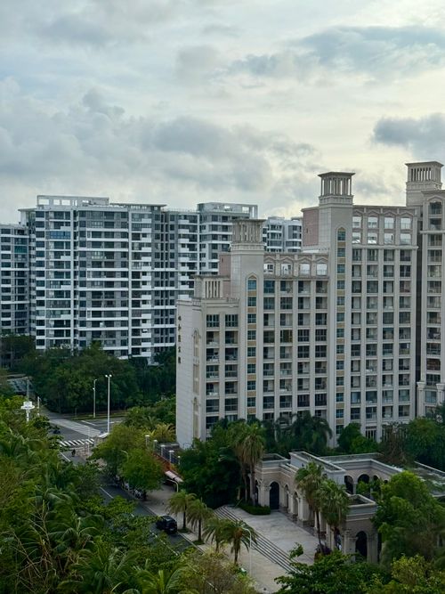 Free Aerial view of modern high-rise condos with palm trees and cloudy skies. Stock Photo