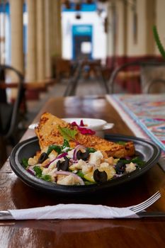 Indulge in a vibrant Mediterranean dish served at a Mexican cafe with rustic charm.
