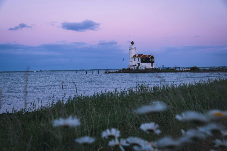 Serene view of a lighthouse during blue hour in Marken, Netherlands.