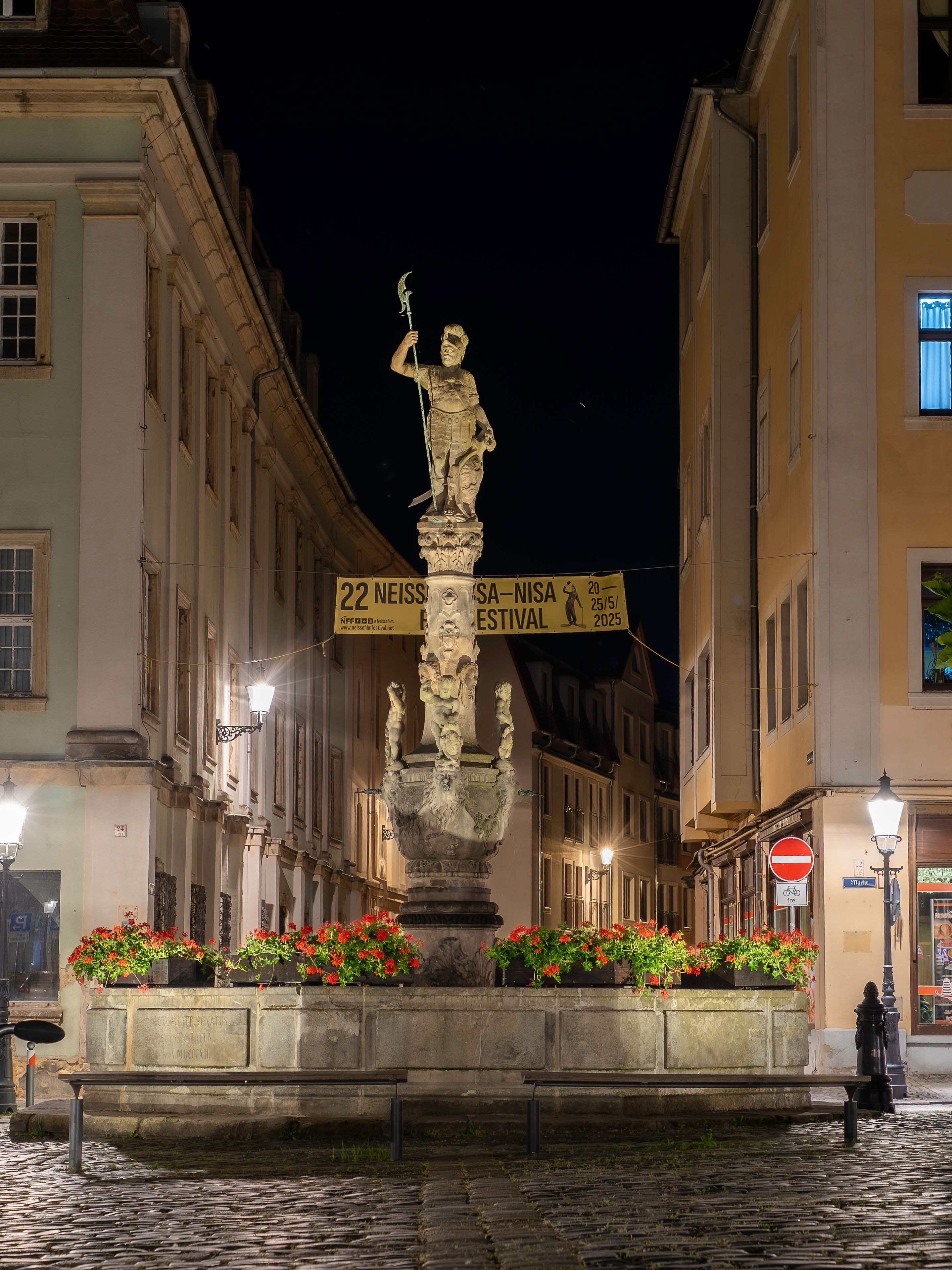 A night view of the iconic Roland Fountain amid Renaissance architecture in Zittau, Germany.