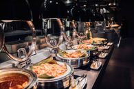 A tempting display of a luxurious buffet with various prepared dishes under warm lighting.