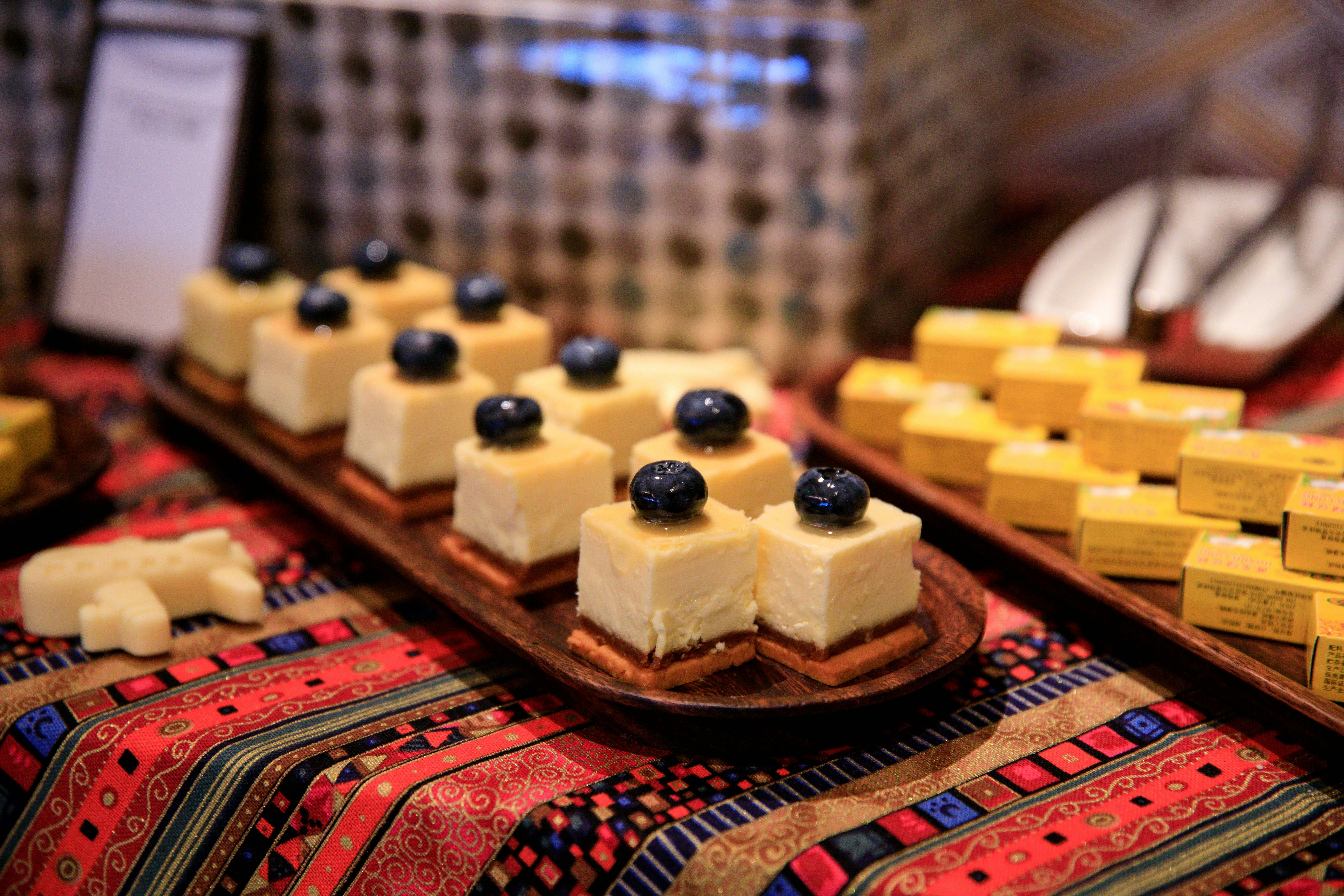 Sliced blueberry cheesecake served on a colorful patterned table, perfect for dessert enthusiasts.