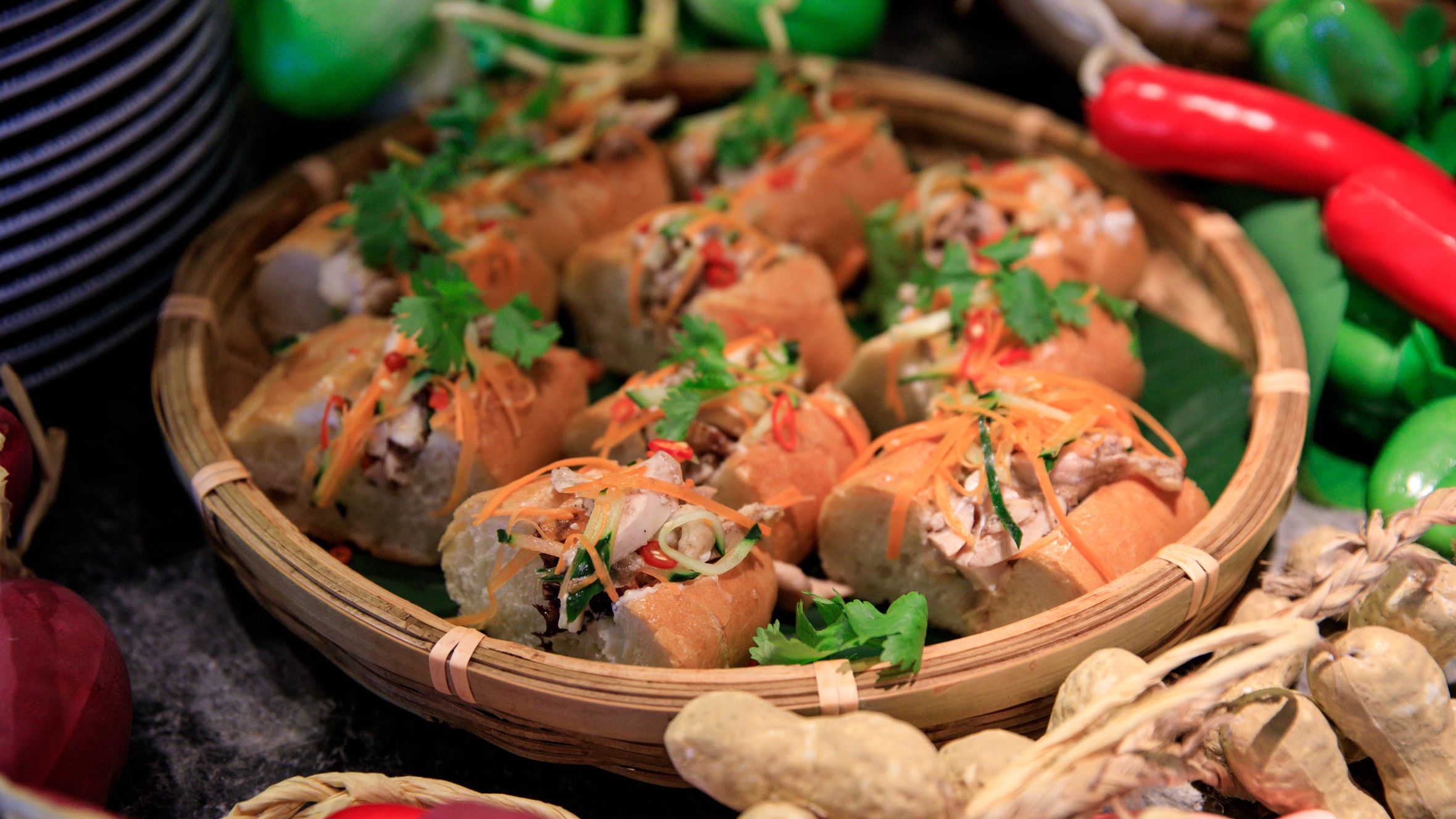 Close-up of a Vietnamese Banh Mi sandwich platter surrounded by fresh vegetables.