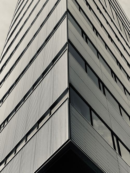 Free Grayscale low angle shot of a modern skyscraper with geometric patterns. Ideal for architecture themes. Stock Photo