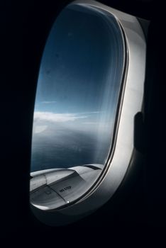 A breathtaking view of the sky and wing from an airplane window at high altitude.