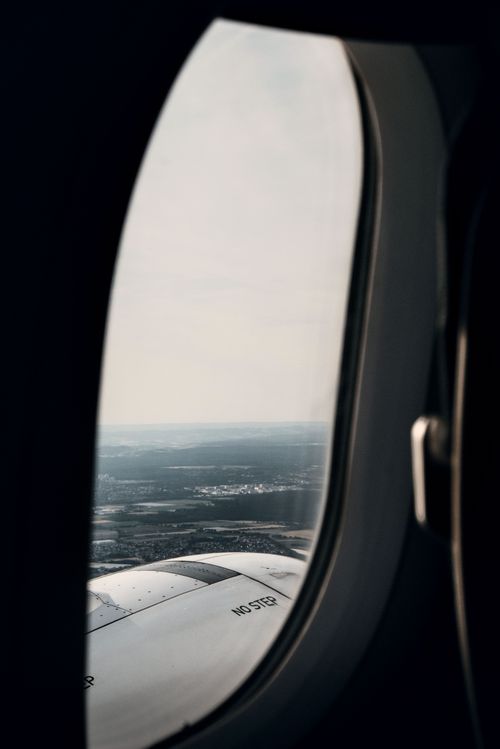 Free View of landscape and airplane wing through a plane window in flight. Stock Photo