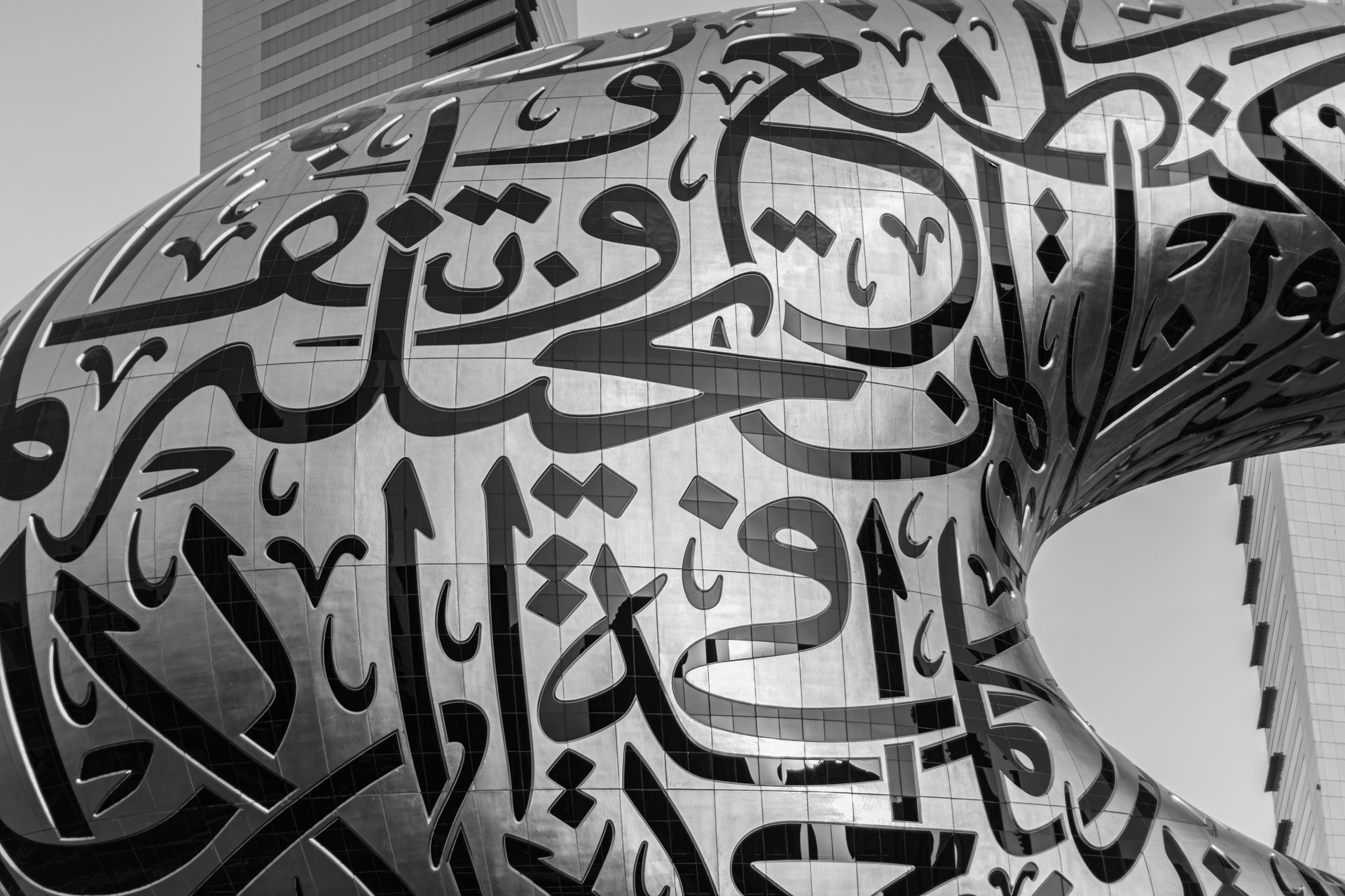 A dramatic black and white close-up of Arabic calligraphy on the Museum of the Future, Dubai, showca