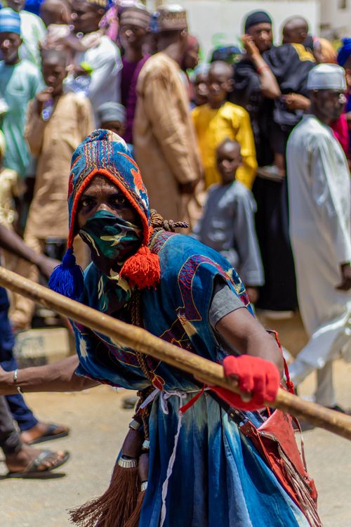 Free Vibrant African festival featuring a masked performer in traditional attire during a celebration. Stock Photo