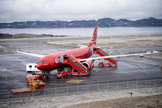 Vibrant red Airbus A330 on the tarmac at Nuuk Airport in Greenland with a stunning mountainous backdrop.
