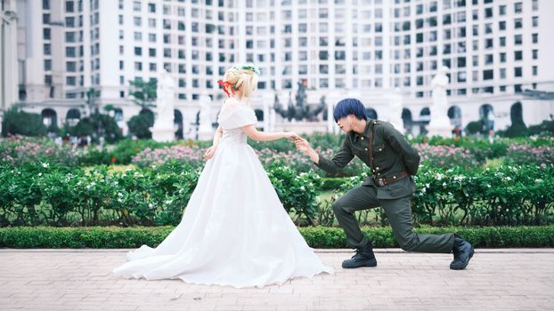 A couple in cosplay enjoying a romantic moment in a garden.
