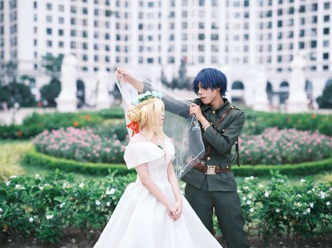 A cosplay couple posed in a garden with a soldier and bride theme.