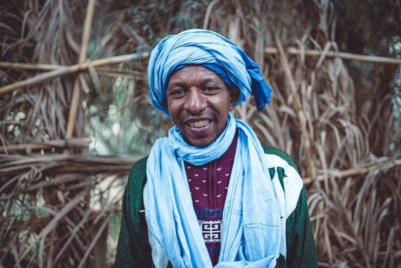 Homme souriant en tenue traditionnelle marocaine avec un turban bleu