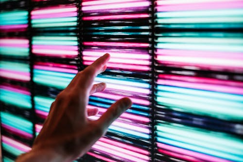 Free Person's Hand Touching Blue and Pink Led Panel Stock Photo