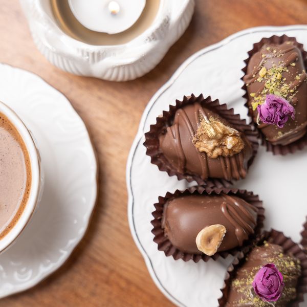 Elegant display of chocolate-covered dates with nuts and coffee, perfect for festive occasions.