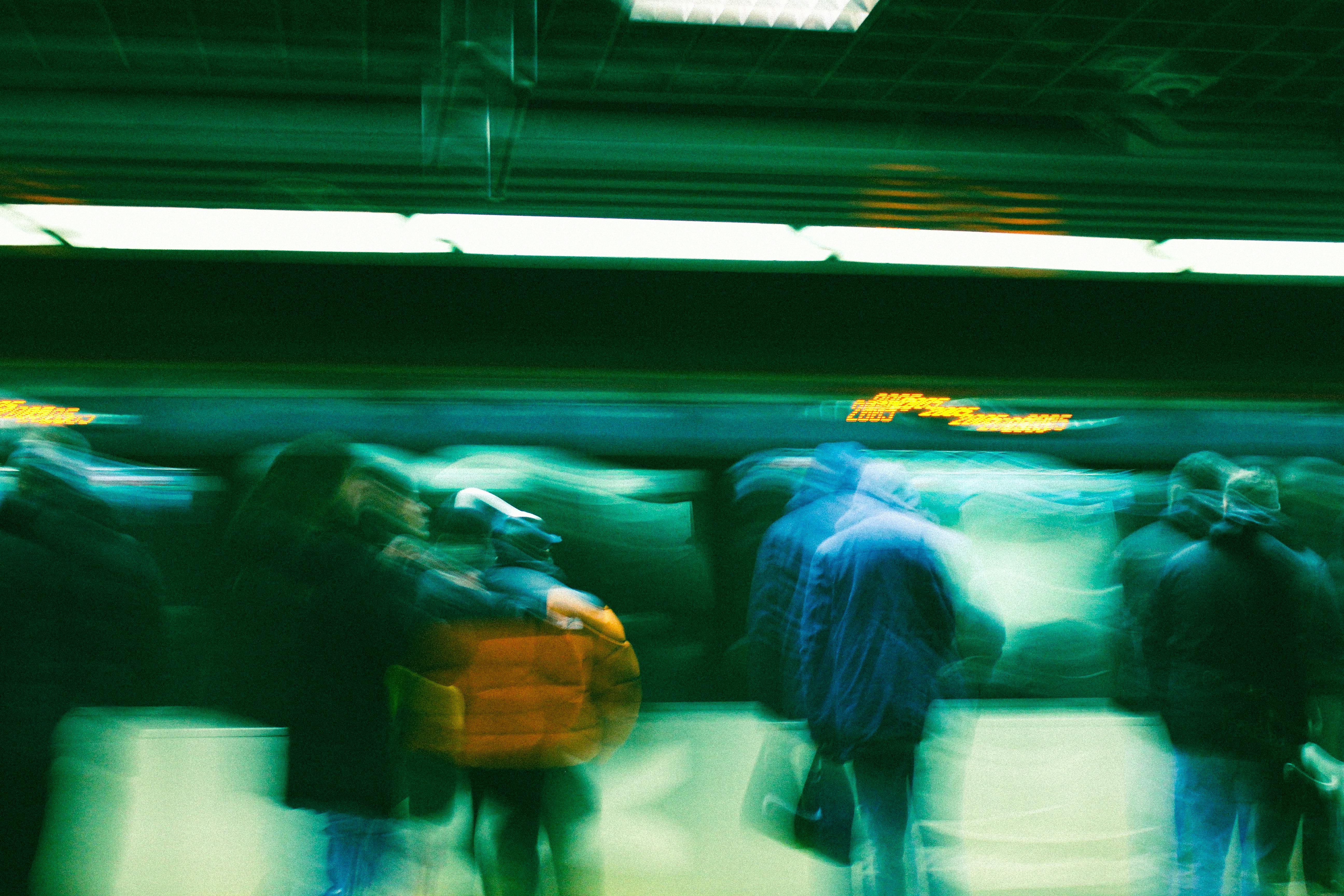 Abstract motion blur of commuters in a subway station, conveying movement and urban life.