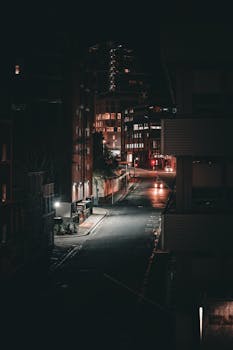 A dimly lit empty street captures the essence of a quiet city night.
