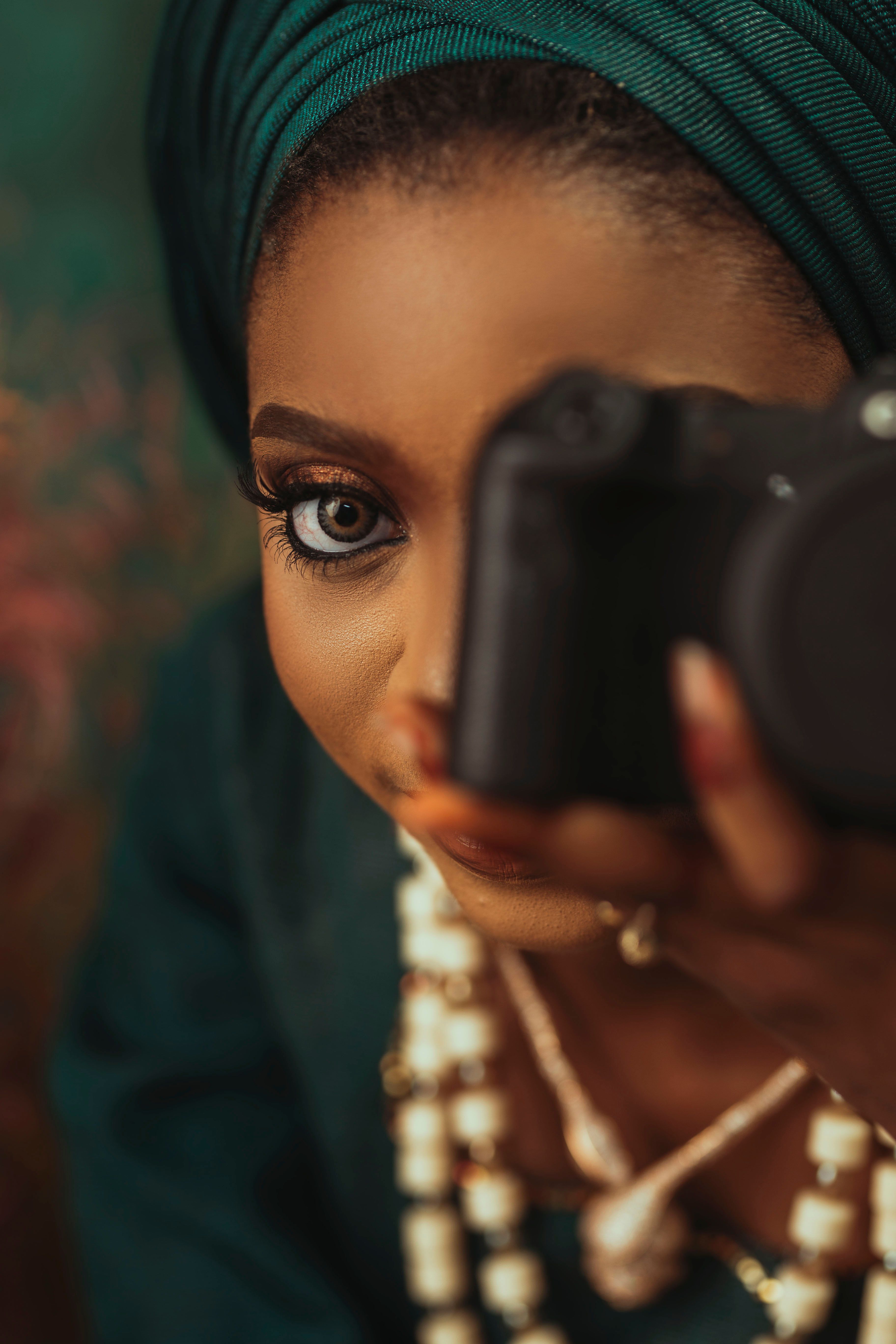 Close-up of a woman capturing an image with a DSLR camera, showcasing elegance.