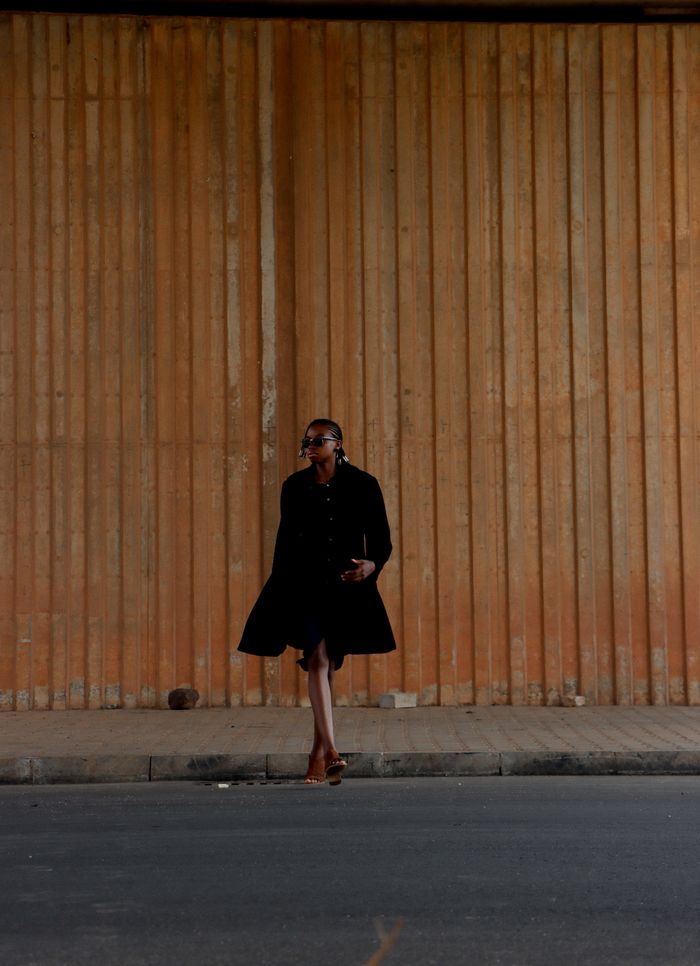 Solo walk past a textured wall — Jessica Iroh on Pexels