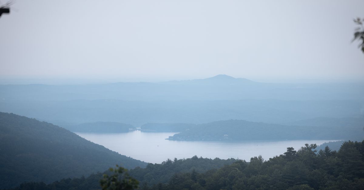Scenic landscape of misty mountains and serene Lake Toxaway in North Carolina.