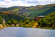 Picturesque view of a river and bridge with lush hills in O Porto, Galicia, España.