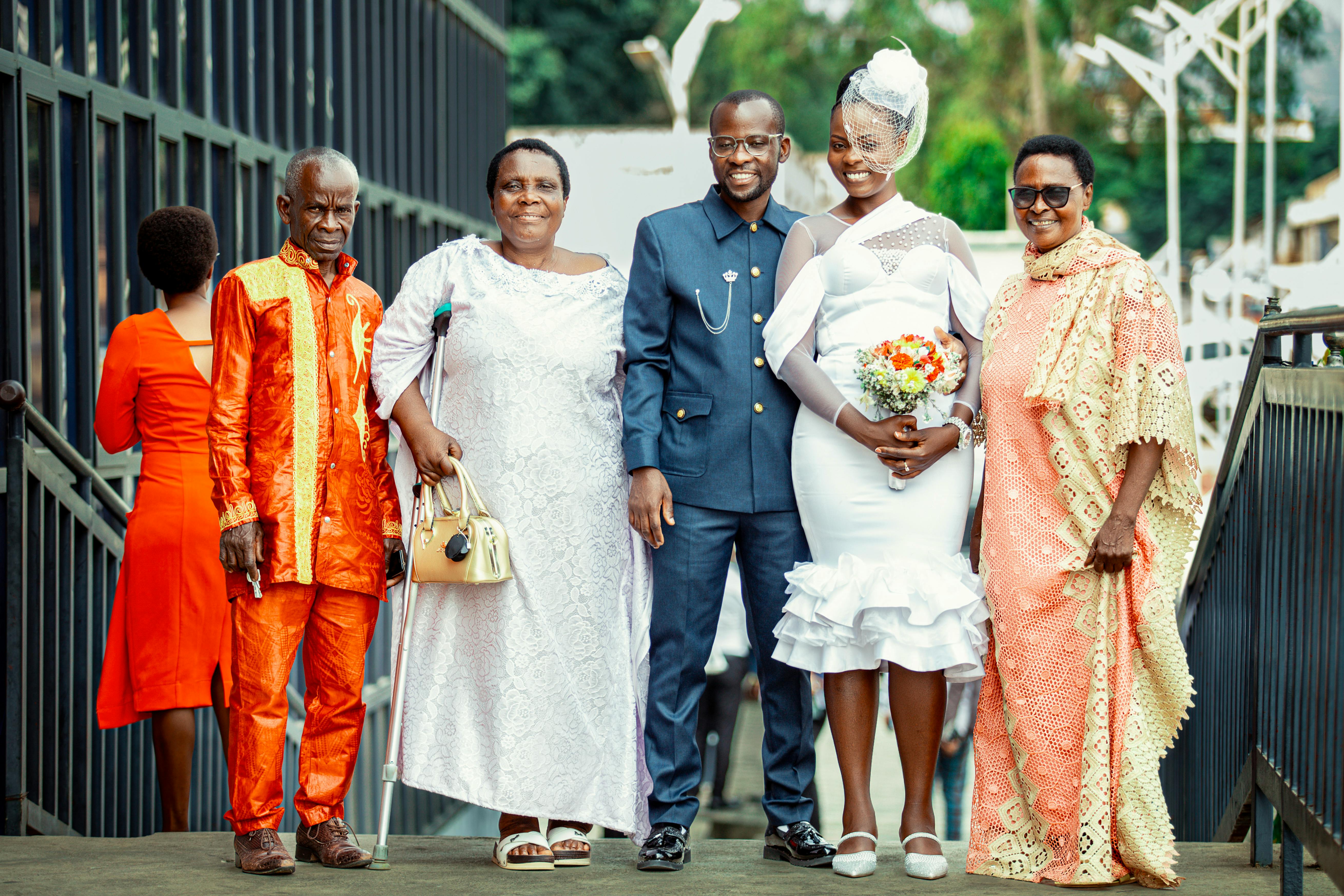 A joyful family celebrates a wedding day with vibrant attire and smiles.