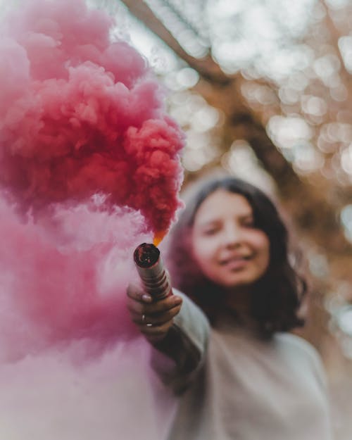 Женщина, держащая розовую дымовую шашку