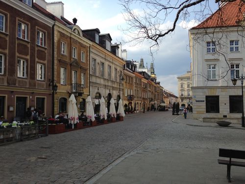 Free View of a historic street in Warsaw, Poland, featuring colorful architecture and outdoor cafes. Stock Photo