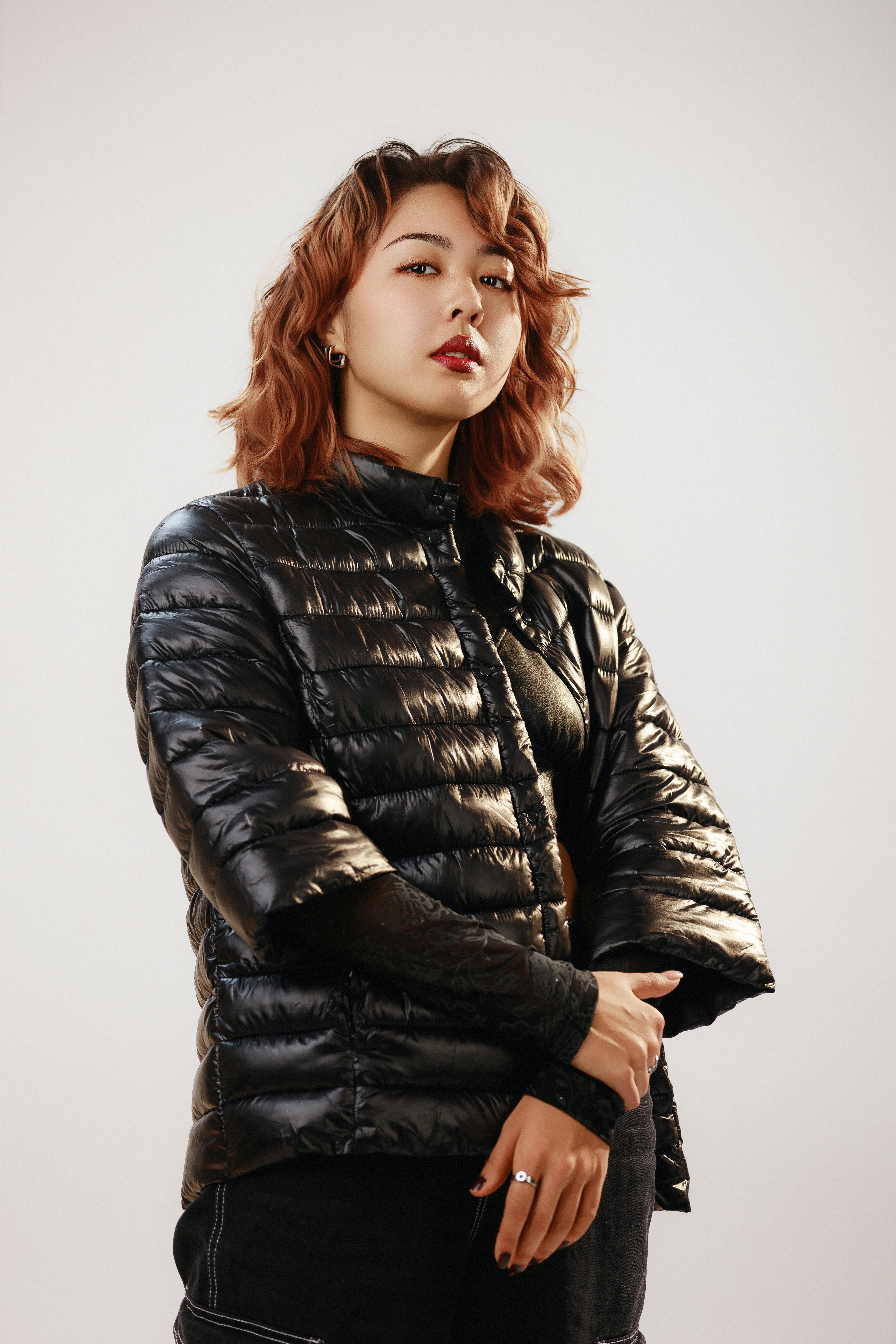 Elegant woman posing confidently in a chic black puffer jacket, showcasing contemporary winter fashi