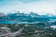 晴朗的天空下，白雪皑皑的山脉与宁静的湖泊尽收眼底